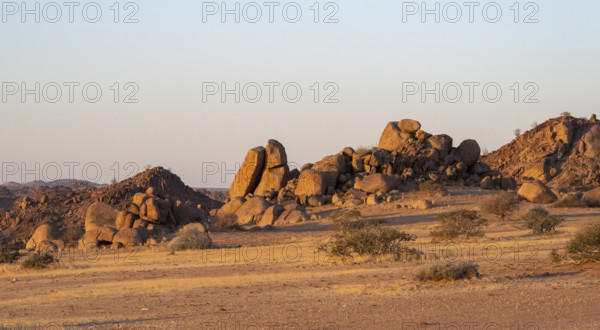 Barren landscape with hills of stacked rocks, desert landscape in the evening light at sunset, Erongo, Damaraland, Namibia
