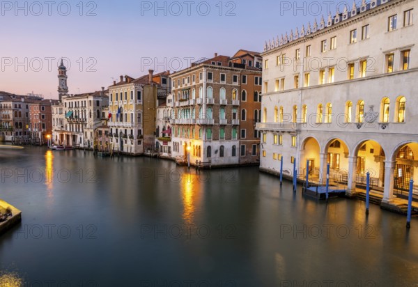 View of the Grand Canal at sunset, picturesque evening mood with illuminated palazzos on the canal and the church tower of the Chiesa Parrocchiale dei Santi Apostoli, long exposure, view from the Rialto Bridge, Venice, Veneto, Italy