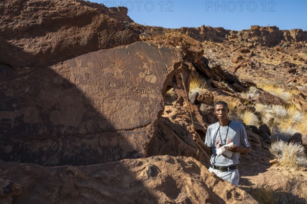 Tourist guide explains the details of the rock engravings at Twyfelfontein, Twyfelfontein, Kunene, Namibia
