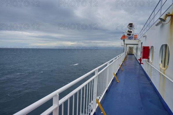 View over the deck of a ferry to the wide sea under a cloudy sky, summer, Cook Strait, North Island, South Island, New Zealand