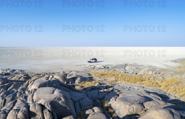 Round rocks of Kubu Island with view over the salt pan, off-road vehicle on the salt pan, Kubu Island (Lekubu), Sowa Pan, Makgadikgadi Salt Pans, Botswana
