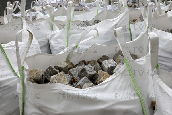 Building site, road construction, granite paving stones packed in big packs, cobblestones