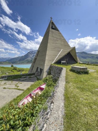 Mont-Cenis Pyramid Museum built in 1967 above the Lac du Mont Cenis in a stylised pyramid as a museum to commemorate the Egyptian campaigns of Emperor Napoleon Bonaparte and the time in front of the construction of the reservoir, old rowing boat in the lower left foreground, Mont Cenis massif, Massif du Mont-Cenis, Graian Alps, Lanslebourg, Rhone-Alpes, France