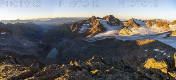 Picturesque high mountain landscape at sunrise with alpenglow, blue glacial lakes, glaciers and rocky mountain peaks in the morning light, view at Becher of mountain peaks Königshofspitz and Sonklarspitze and Schwarzwandspitz with glacier Übeltalferner, Stubai Alps, South Tyrol, Italy