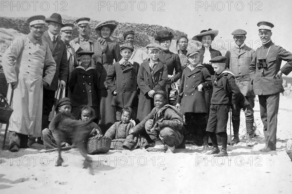 German families posing with Chinese children, China around 1900. Photograph around 1900 from the album of a German officer