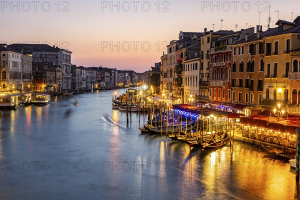 View of the Grand Canal at the blue hour, picturesque evening mood with illuminated palazzos on the canal, long exposure, view from the Rialto Bridge, Venice, Veneto, Italy