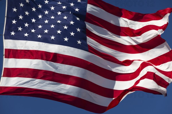 American flag waving in the wind against deep blue sky