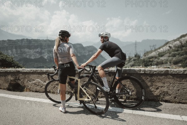Woman and man cycling on Lake Garda in Italy. Sunny weather and dolce vita