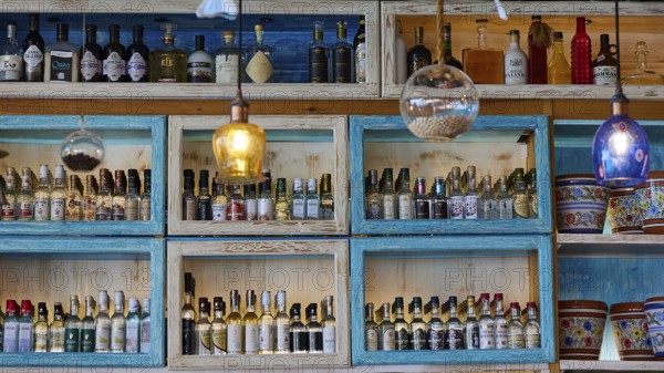 Decoratively arranged shelves with a variety of bottles and colourful elements, Taverna, Stegna Beach, Stegna Viewpoint, Stegna, East Coast, Rhodes, Dodecanese, Greek Islands, Greece