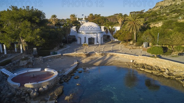 Drone shot, morning light, building with dome on a small beach with turquoise water, surrounded by palm trees and Mediterranean vegetation, Kalithea, Kallithea, thermal baths, spa, Rhodes, Dodecanese, Greek Islands, Greece