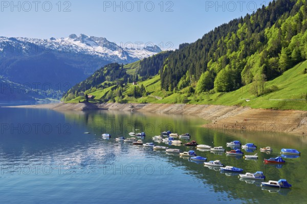 Motorboats moored at the reservoir, snow-covered Alps in the background, Lake Wägital, Canton Schwyz, Switzerland