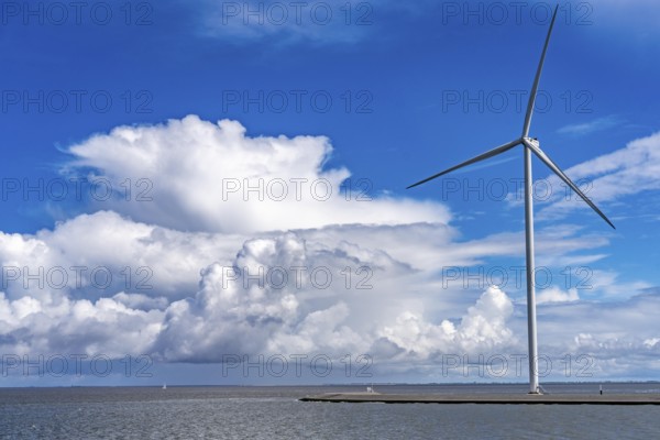 Strekdammen Wind Farm, wind farm at the seaport of Eemshaven in the Netherlands, built on offshore breakwaters, 2 GE Cypress 5, 5 MW turbines, with 158 metre blade diameter, together produce 11 MW of power, can supply 15, 500 households with electricity from wind, cumulus cloud over the North Sea, Netherlands