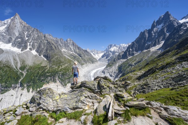 Picturesque mountain landscape with imposing mountain peaks and glaciers, mountaineer on hiking trail, Grand Balcon Nord, glacier tongue Mer de Glace, behind Grandes Jorasses, Mont Blanc massif, Montenvers, Chamonix, Haute-Savoie, France