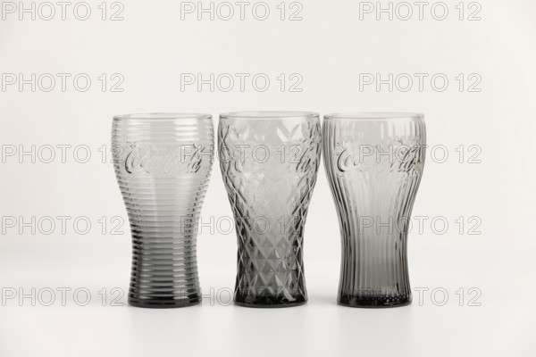 Three stylish, differently designed cola glasses in transparent and black tones