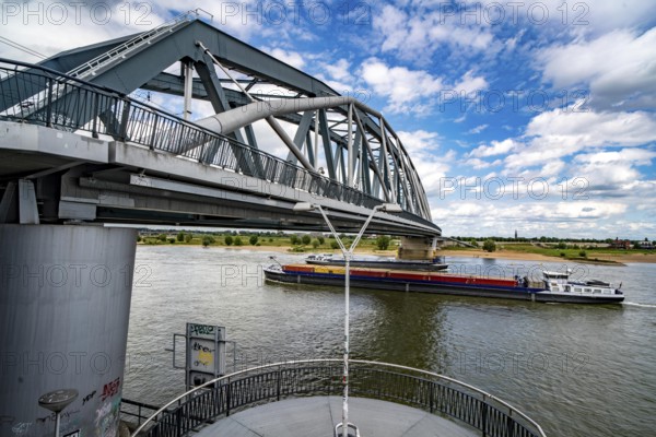 Cycle and pedestrian bridge Snelbinder Brug, over the river Waal near Nijmegen, was added to the existing railway bridge, fast cycle path connection from the city centre of Nijmegen and the new housing estates in the Waalsprong district, Netherlands