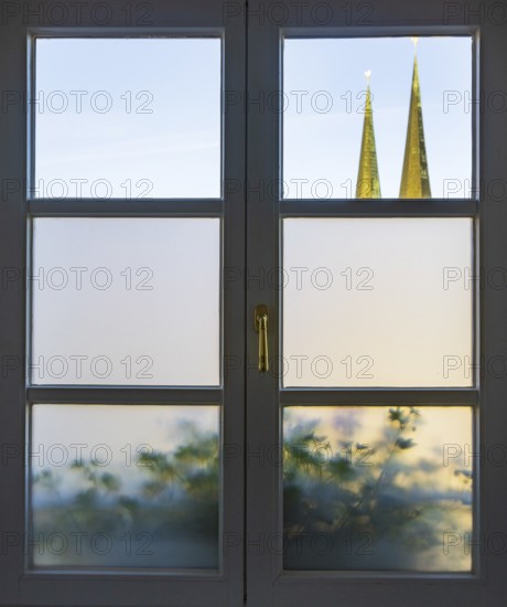 View through a closed window to the collegiate parish church of St Philip and St James, place of pilgrimage, Altötting, Upper Bavaria, Bavaria, Germany