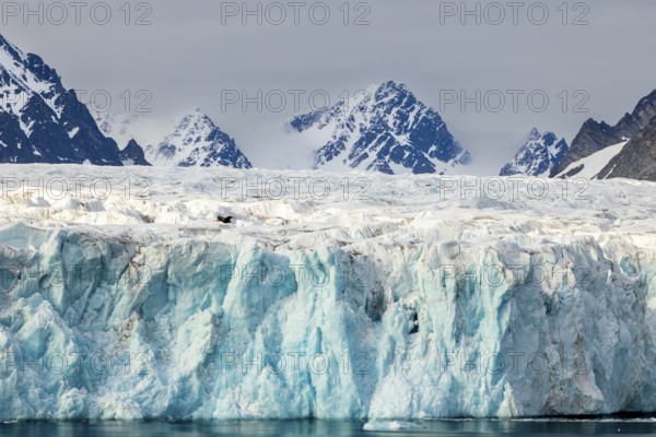 Glacier tongue, ice, ridge in front of mountain range, snow, sea, Lillienhöökbreen, Spitsbergen, Svalbard