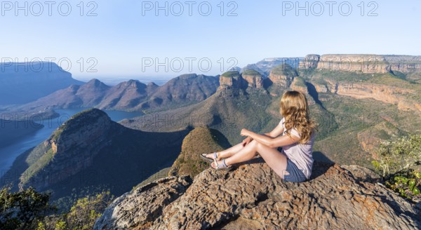 Hiker enjoying sunset at Blyde River Canyon with Three Rondawels peak, view of canyon with Blyde River and table mountains in the evening light, Canyon landscape, Panorama Route, Mpumalanga, South Africa