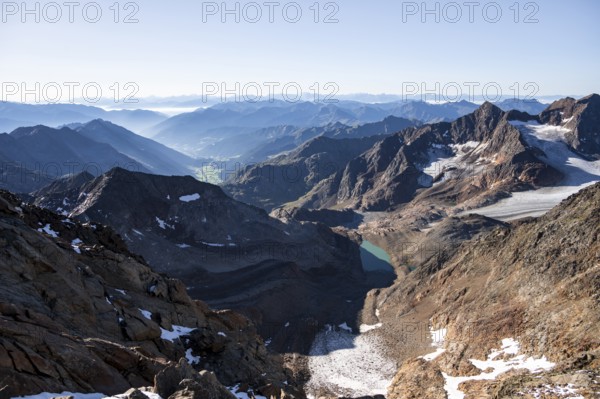 View of mountain panorama into the Ridnaun valley with blue glacier lake, ascent to the Wilder Freiger, Stubai Alps, South Tyrol, Italy
