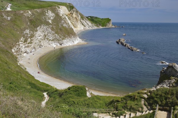 Curved coastline with sandy beach and cliffs, calm sea, Durdle Door, Weymouth, Dorset, England, United Kingdom