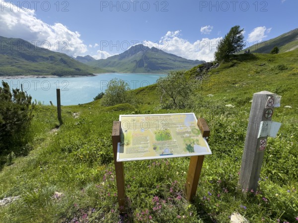 In the foreground information board with explanations about Jardin Alpin, in the background Lac du Mont Cenis reservoir, Mont Cenis massif, Massif du Mont-Cenis, Graian Alps, Lanslebourg, Rhone-Alpes, France