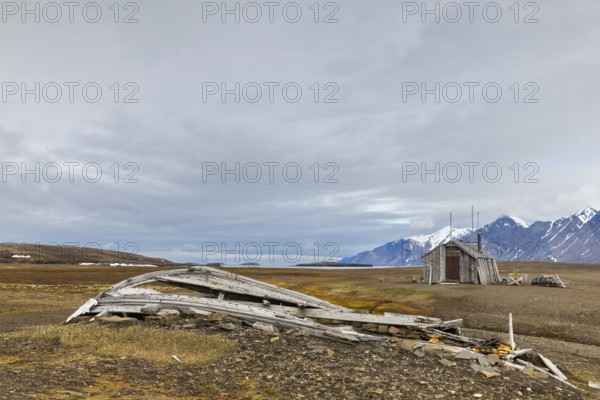 Broken wooden boat in front of hunting hut, wooden hut, Bamsebu, Spitsbergen, Svalbard