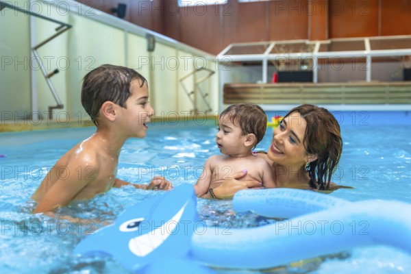 Mother and children enjoying time together, playing with inflatable toys in a swimming pool, promoting family bonding and water safety