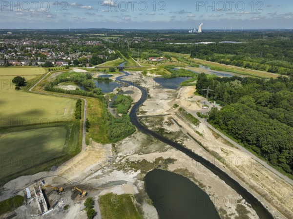 Dortmund, Castrop-Rauxel, North Rhine-Westphalia, Germany - River renaturalisation, renaturation of the Emscher, flood retention basin HRB Mengede. A new floodplain landscape is being created at the Emscher-Auen farm, expanding the area for flood protection during heavy rainfall and for biodiversity. The previously straightened Emscher is being given curves again and can meander through its new floodplain. Following the construction of a parallel sewer, the Emscher has been completely free of sewage since 2022. The river was previously an open, above-ground mixed water channel with rainwater and wastewater. At the back right, the Uniper coal-fired power plant Datteln 4 power station