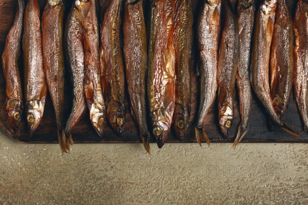 Cold smoked capelin, on a wooden chopping board, no people