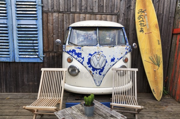 Original terrace, front of VW bus T1, Bulli, vintage car, wooden facade with surfboard as decoration, table and wooden chairs, café, beach bar, Hüde, Dümmer, Dümmer-See, Germany