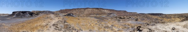 Dry landscape with yellow grass and black volcanic hills, Burnt Mountain, Damaraland, Kunene, Namibia