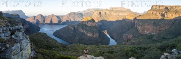 Hiker enjoying panorama, sunset at Blyde River Canyon with Three Rondawels peak, view of canyon with Blyde River and table mountains in the evening light, canyon landscape, Panorama Route, Mpumalanga, South Africa
