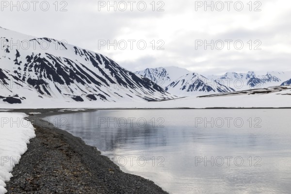 Pebble beach in a bay, mountain range, snow, Mushamna, Spitsbergen, Svalbard
