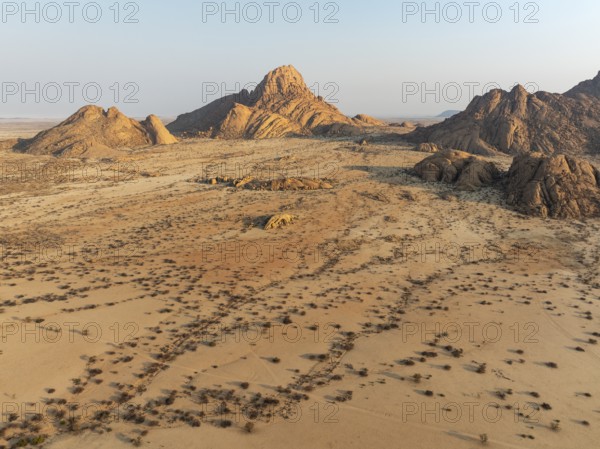The isolated Spitzkoppe mountain (1728 m) majestically rises above the surrounding desert plains. Aerial view. Drone shot. Damaraland, Namibia