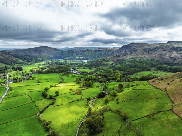 Farms and Mountains over road A591 from a drone, Grasmere Lake, Grasmere, Ambleside, Lake District, Westmorland, Cumbria, UK