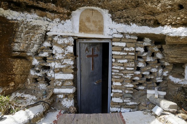 A rustic stone door with a cross symbolises a cave entrance that carries religious significance, Chapel, Agios Nikolaos, Rock Chapel, Oasis Beach, East Coast Rhodes, Rhodes, Dodecanese, Greek Islands, Greece