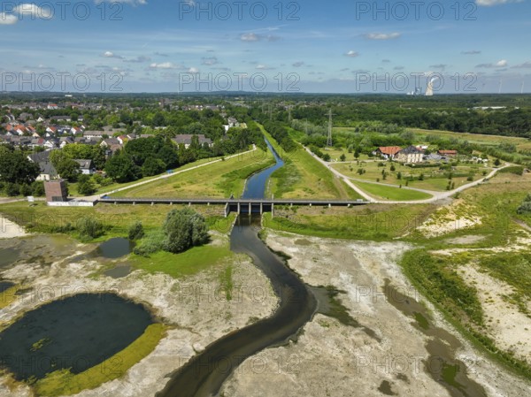 Dortmund, Castrop-Rauxel, North Rhine-Westphalia, Germany - River renaturalisation, renaturation of the Emscher, flood retention basin HRB Mengede. A new floodplain landscape is being created at the Emscher-Auen farm, expanding the area for flood protection during heavy rainfall and for biodiversity. The previously straightened Emscher is being given curves again and can meander through its new floodplain. Following the construction of a parallel sewer, the Emscher has been completely free of sewage since 2022. The river was previously an open, above-ground mixed water channel with rainwater and wastewater. At the back right, the Uniper coal-fired power plant Datteln 4 power station