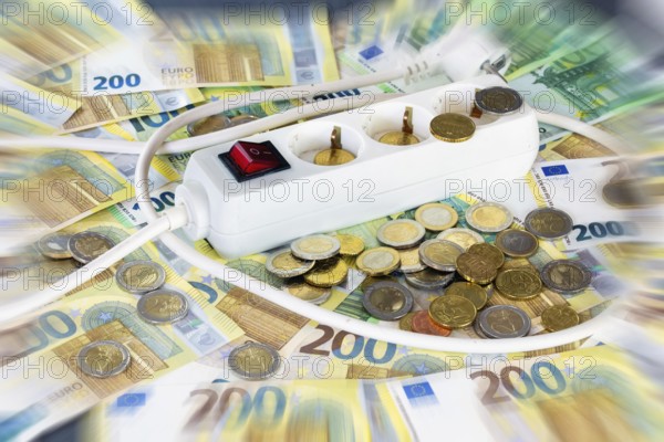 Symbolic image of electricity costs: multiple socket outlet with euro banknotes and euro coins