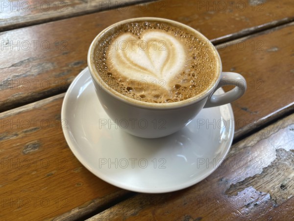 Cup of cappuccino, flat white, with heart-shaped milk foam, wooden table, Stuttgart, Baden-Württemberg, Germany