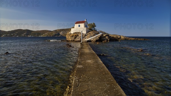 White chapel with red roof on a small island, connected to the mainland by a footbridge, chapel, church, Agios Isidoros, rocky islet, Bay of Gourna, Kokkali, Leros, Dodecanese, Greek Islands, Greece