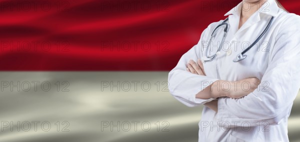 Doctor with crossed arms on Indonesia flag. Indonesia health and care concept. Female doctor on Indonesia flag