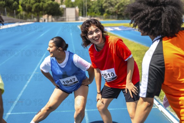 Runners stretching their legs on a vibrant blue track, recovering after a race, embodying teamwork and the spirit of fitness