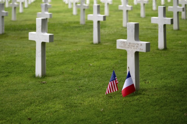 US flag and French flag at the grave of John S Brannon jr, gravestones, war graves, military graves, military cemetery, American Normandy Cemetery, Normandy American Cemetery and Memorial, Omaha Beach, D-Day, Operation Overlord, Saint-Laurent-sur-Mer near Colleville-sur-Mer, Normandy, Calvados, France