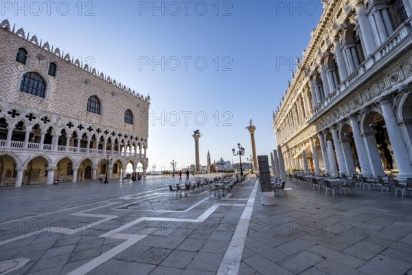 Chairs and tables of cafes at Piazetta San Marco, Doge's Palace and Colonna di San Marco and Colonna di San Todaro, in the morning light, St Mark's Square, Venice, Veneto, Italy