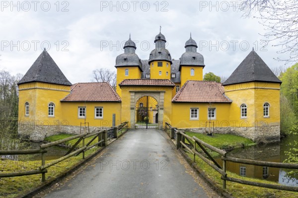 Schloss Holte, Schloss Holte-Stukenbrock, North Rhine-Westphalia, Germany, Baroque yellow castle, hunting lodge with towers and moat under a grey sky