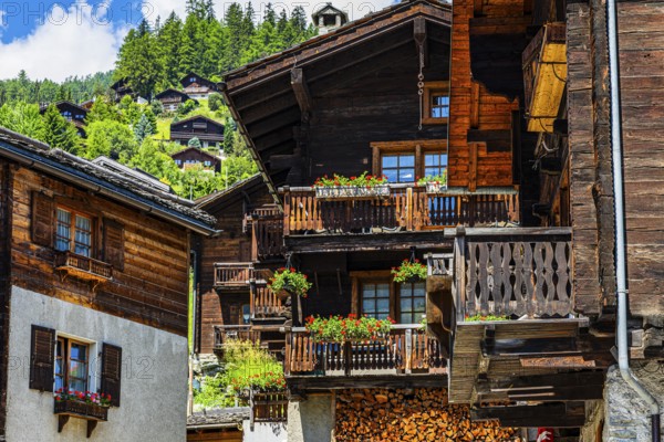 Old wooden houses in log construction, decorated with flowers, historic village centre, Grimentz, Val d'Anniviers, Valais Alps, Canton Valais, Switzerland