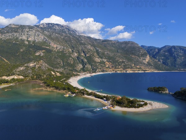 View of a beach with a peninsula surrounded by mountains and blue sea under a clear sky with clouds, aerial view, Fethiye, Mugla, Mugla, Aegean Sea, Turkey