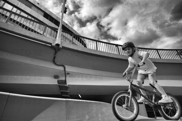 Boy, blonde, 6 years, riding bicycle, bike, crash helmet, subway, urban, concrete, black and white, Stuttgart, Baden-Württemberg, Germany