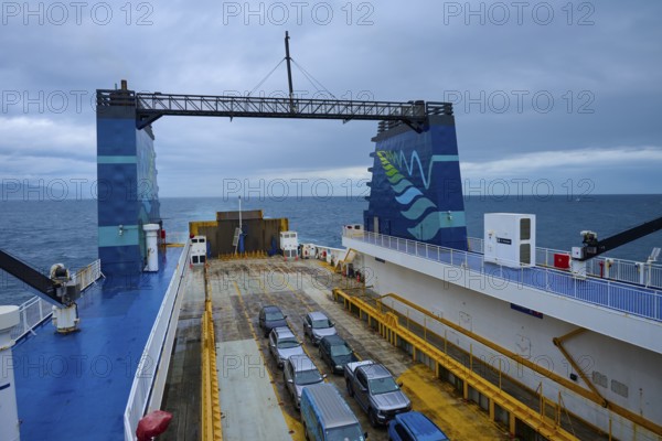 View from a ferry onto several parked cars, with sea and clouds on the horizon, summer, Cook Strait, North Island, South Island, New Zealand