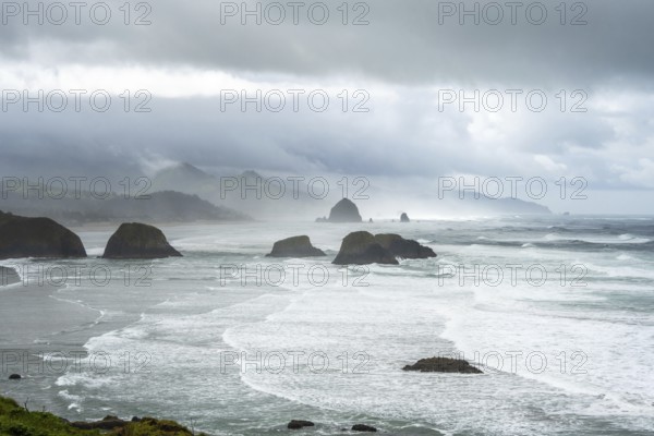 A rugged coastal landscape with rocks in the sea and a cloudy sky, Indian Beach, Oregon, USA, North America